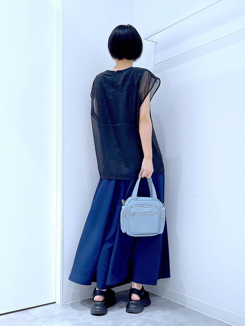 ブラック系のスニーカー、ブルー系のショルダーバッグ、ブルー系のその他パンツを着用したレディースの夏コーディネートの5枚目の写真