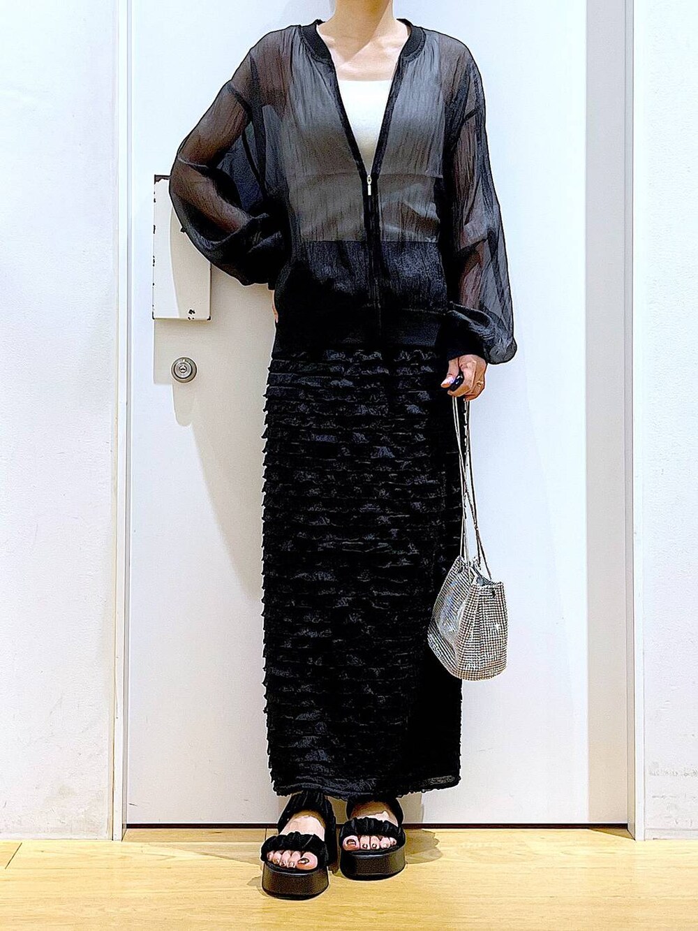 ブラック系のサンダル、ブラック系のブルゾン、ホワイト系のニット/セーターを着用したレディースの夏コーディネートの6枚目の写真