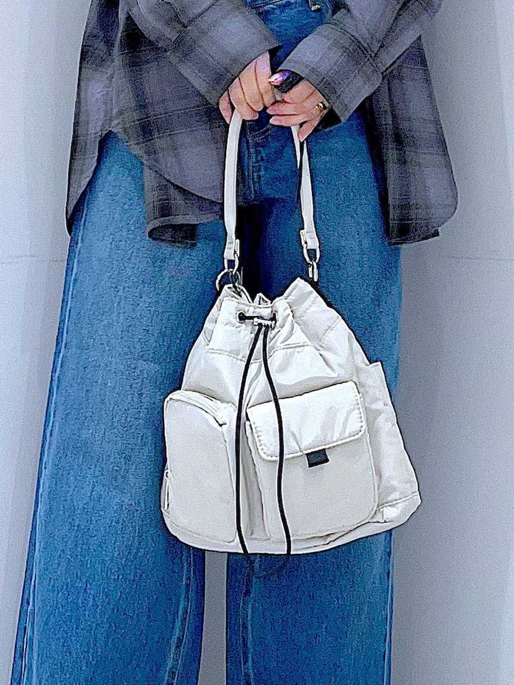ブルー系のデニムパンツ、グレー系のシャツ/ブラウス、ホワイト系のハンドバッグを着用したレディースの秋コーディネートの9枚目の写真