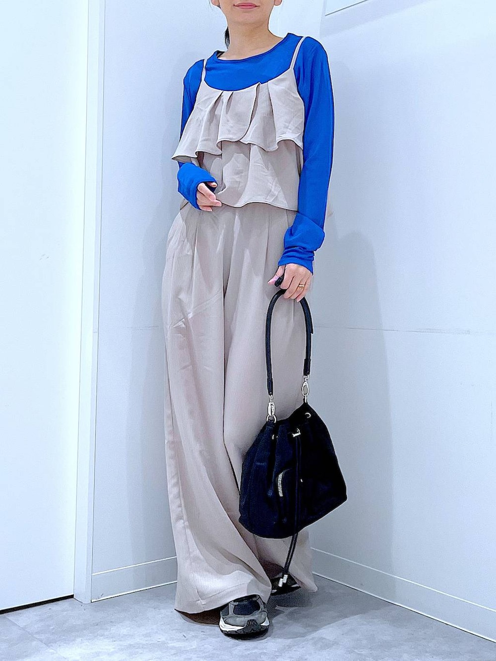 ベージュ系のサロペット/オーバーオール、ブラック系のショルダーバッグ、グレー系のシュシュを着用したレディースの春コーディネートの6枚目の写真