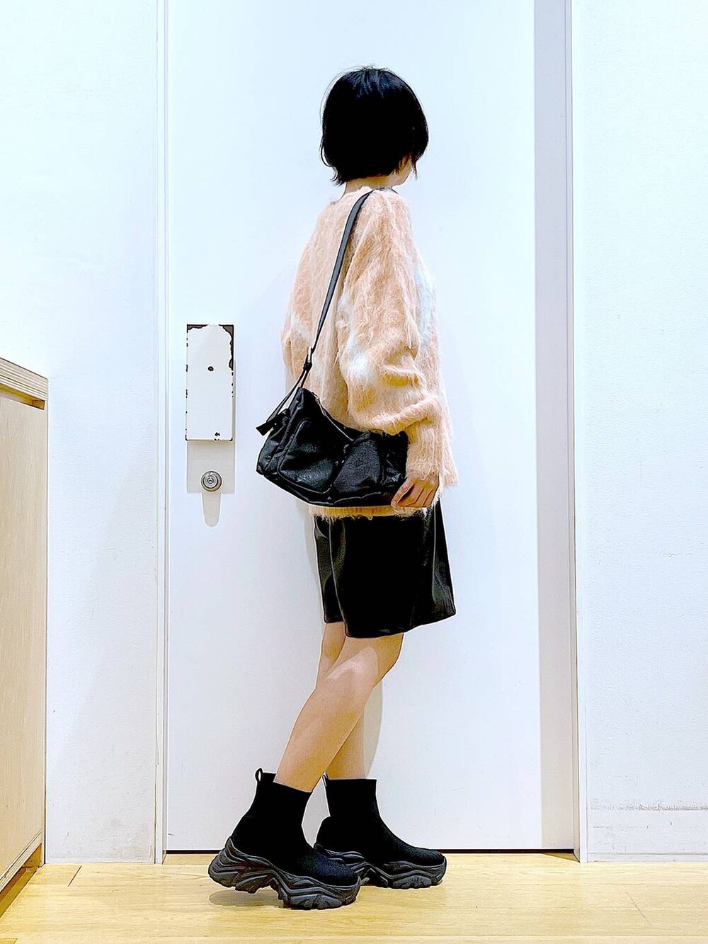 ピンク系のニット/セーター、ブラック系のブーツ、ブラック系のショルダーバッグを着用したレディースの冬コーディネートの4枚目の写真