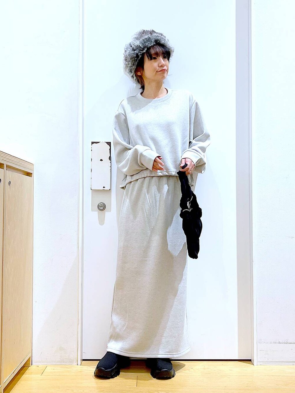 ブラック系のブーツ、ブラック系のショルダーバッグ、ベージュ系のスウェットを着用したレディースの冬コーディネートの2枚目の写真