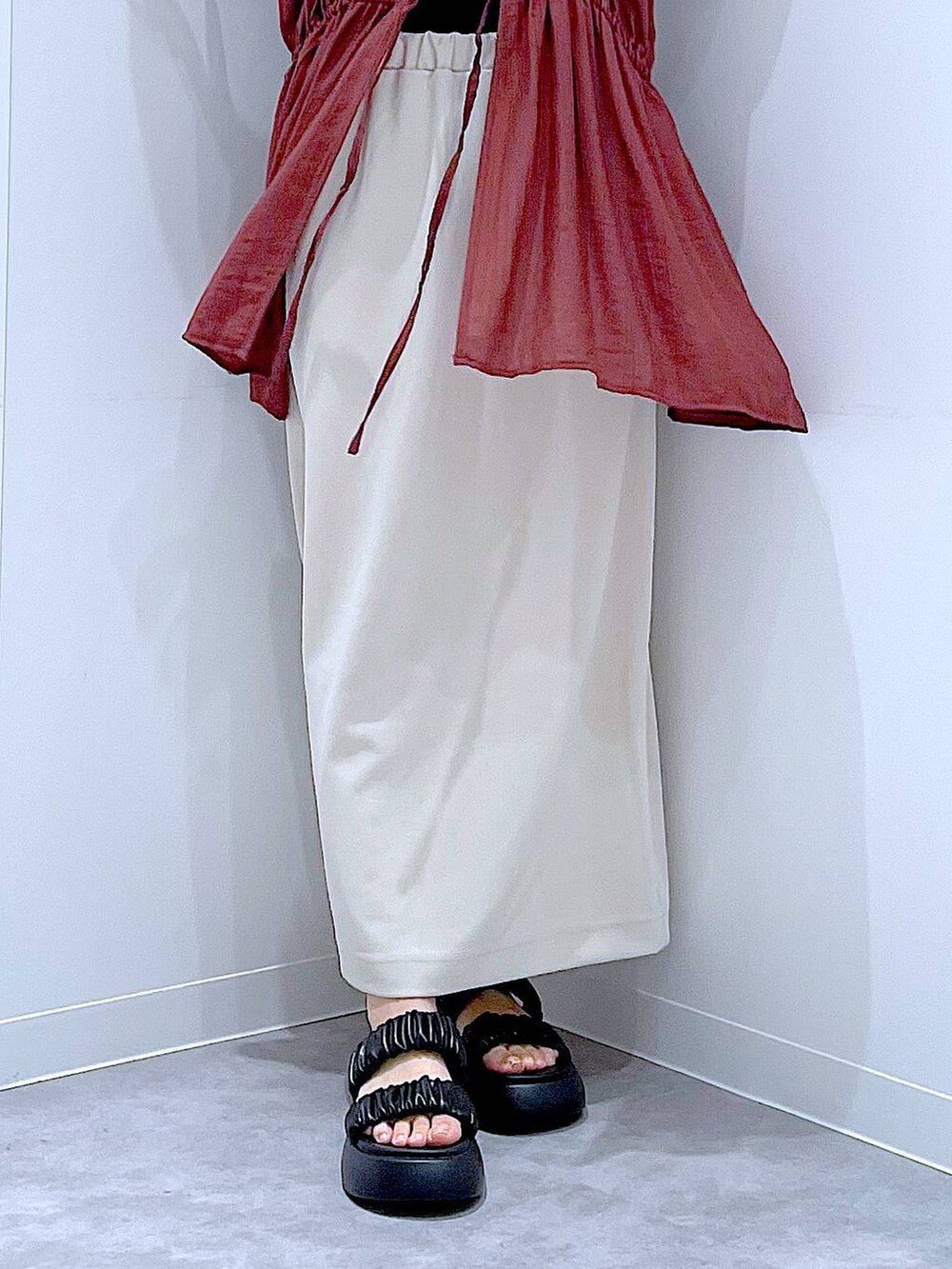 ブラック系のサンダル、ベージュ系のスカート、ブラック系のショルダーバッグを着用したレディースの秋コーディネートの8枚目の写真