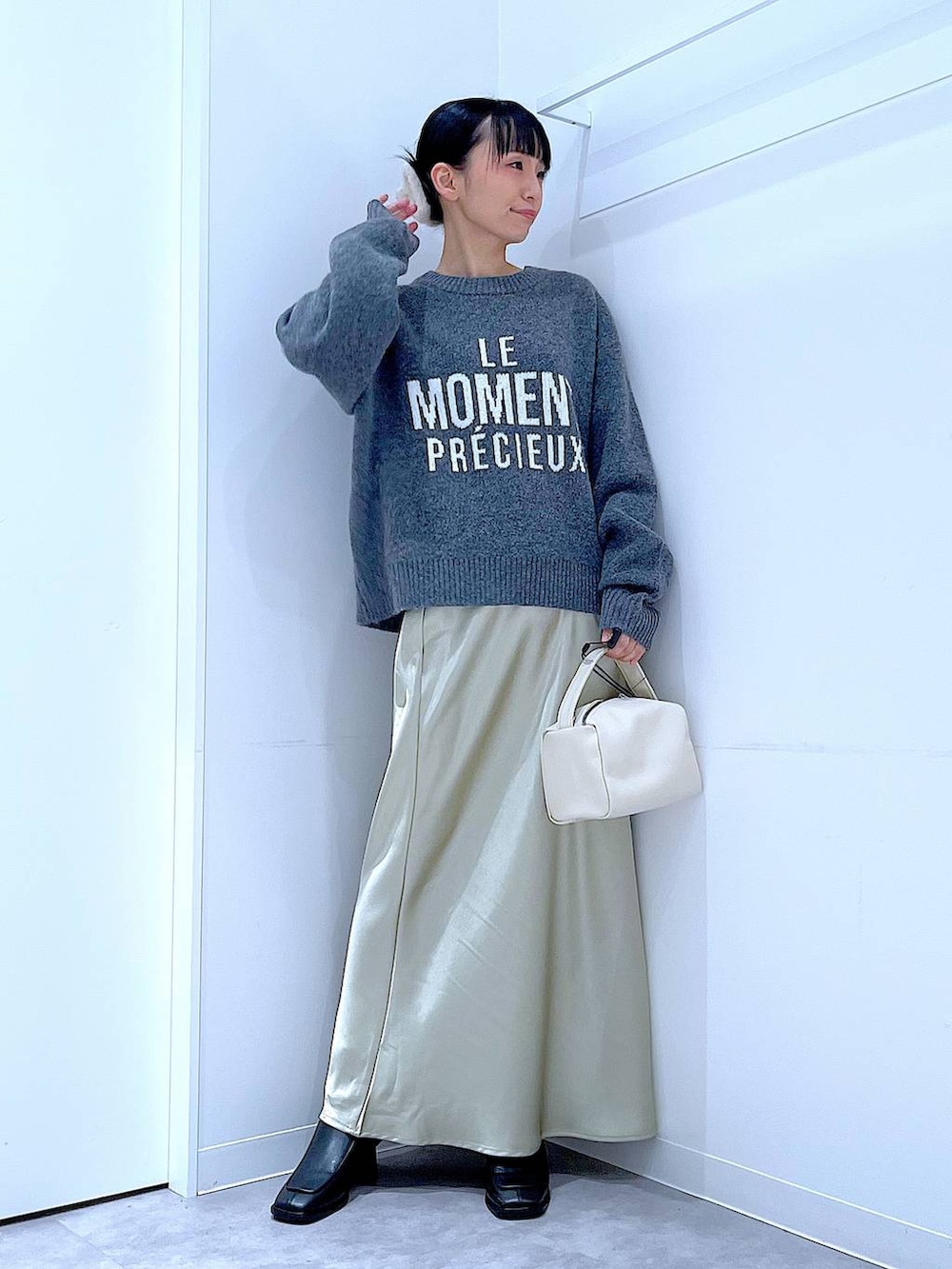ブラック系のブーツ、グレー系のニット/セーター、ホワイト系のショルダーバッグを着用したレディースの冬コーディネートの2枚目の写真