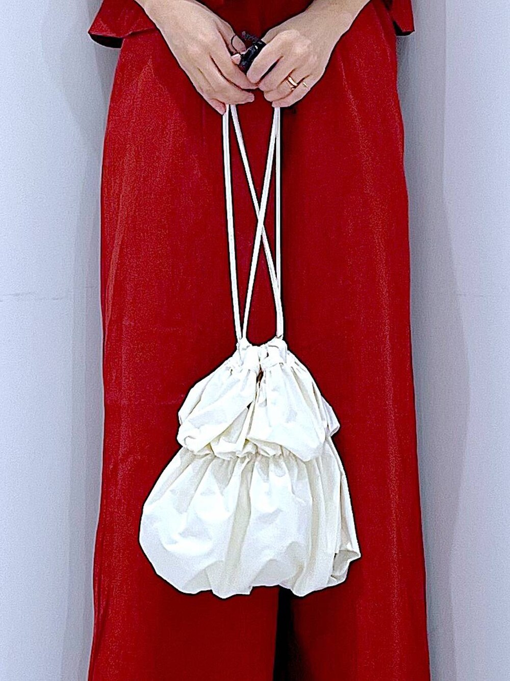 ブラック系のスニーカー、ホワイト系のショルダーバッグ、レッド系のつなぎ/オールインワンを着用したレディースの夏コーディネートの9枚目の写真