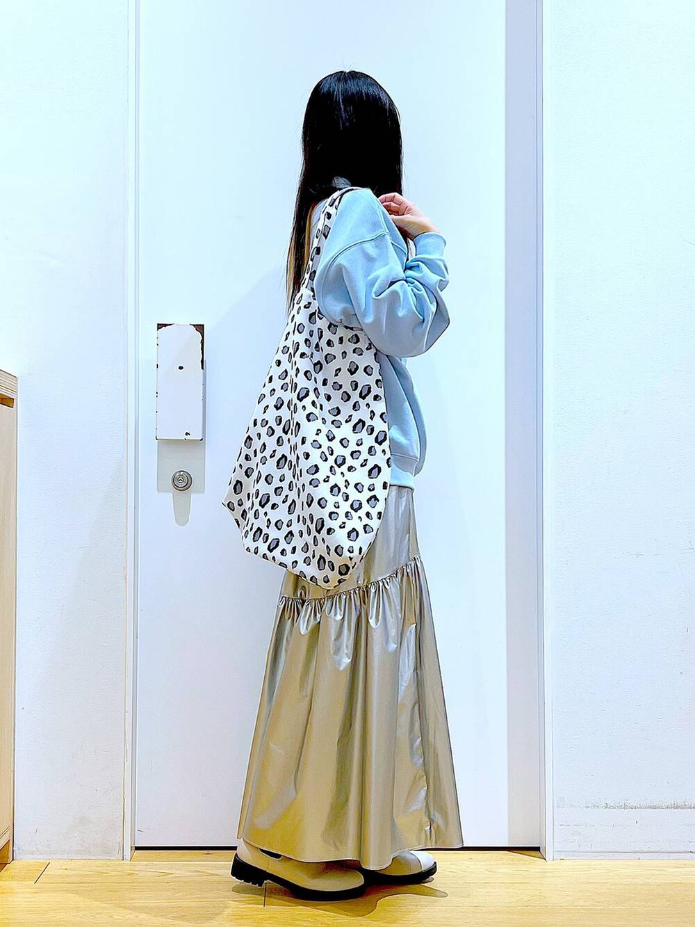 ブルー系のスウェット、シルバー系のスカート、ベージュ系のブーツを着用したレディースの春コーディネートの4枚目の写真