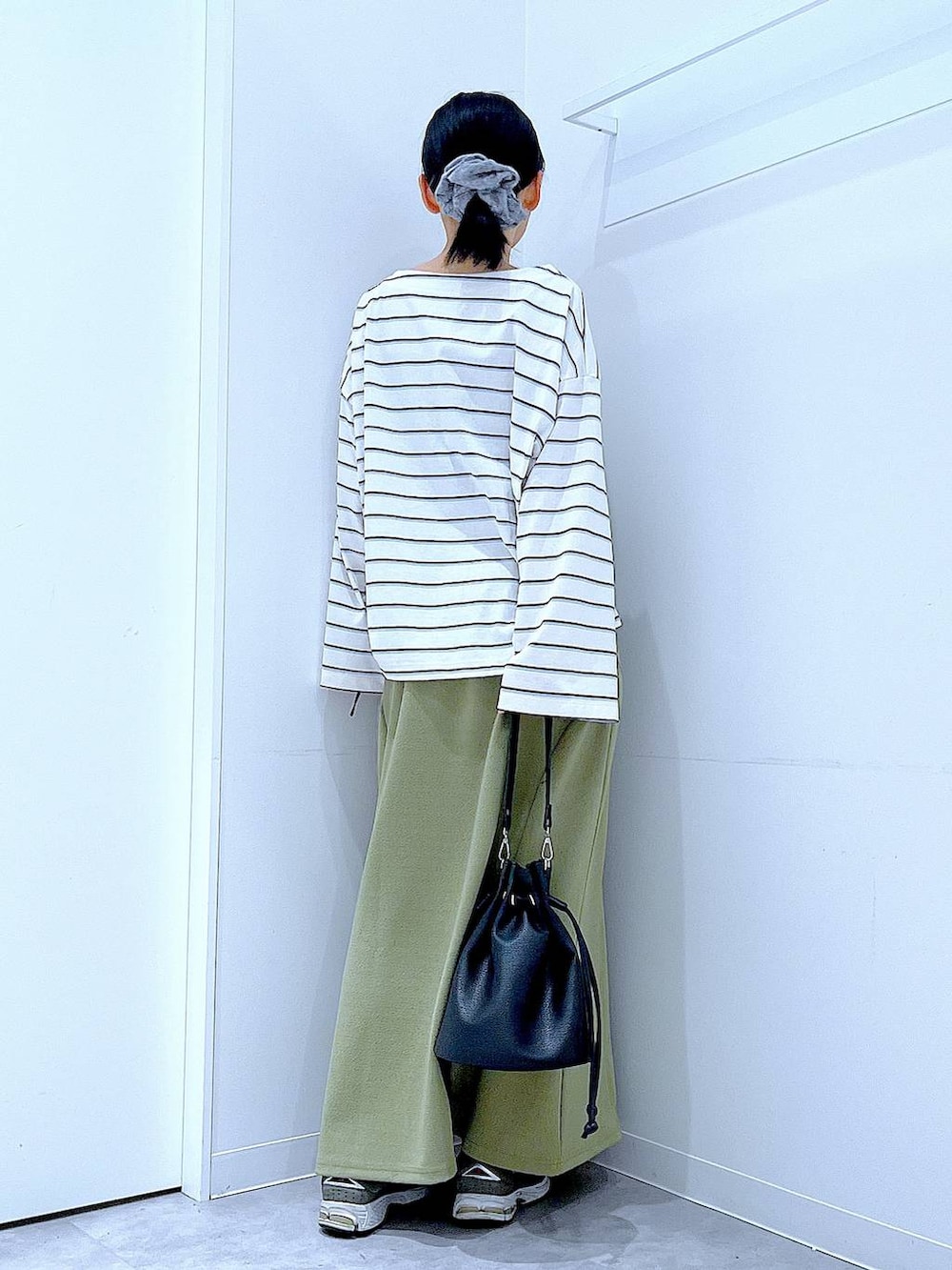 ブラック系のショルダーバッグ、グリーン系のスカート、ホワイト系のTシャツ/カットソーを着用したレディースの冬コーディネートの5枚目の写真