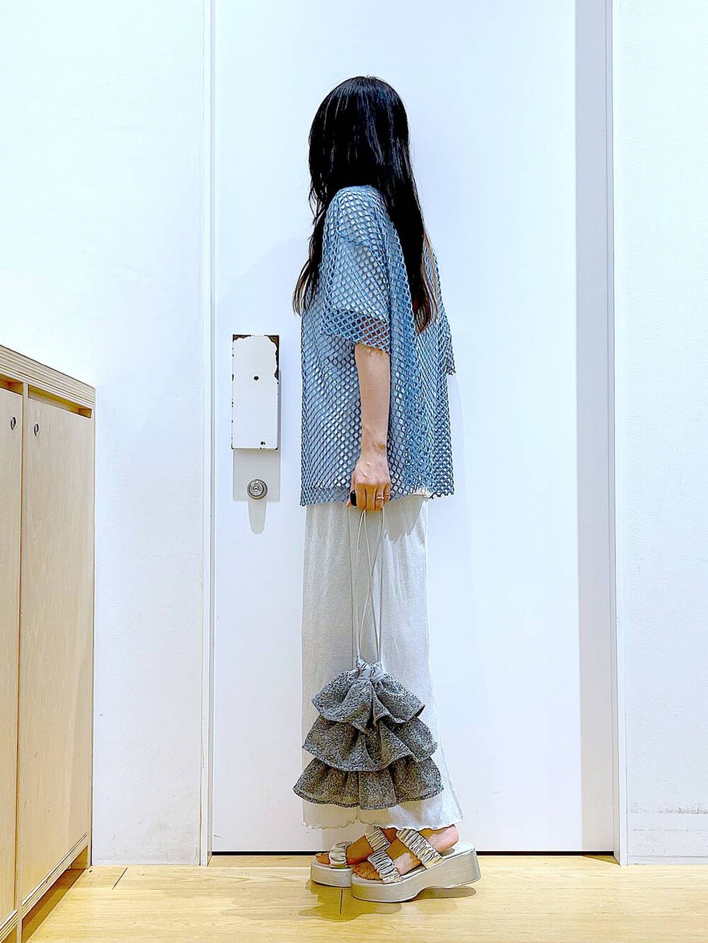 グレー系のスカート、シルバー系のショルダーバッグ、ホワイト系のTシャツ/カットソーを着用したレディースの夏コーディネートの3枚目の写真