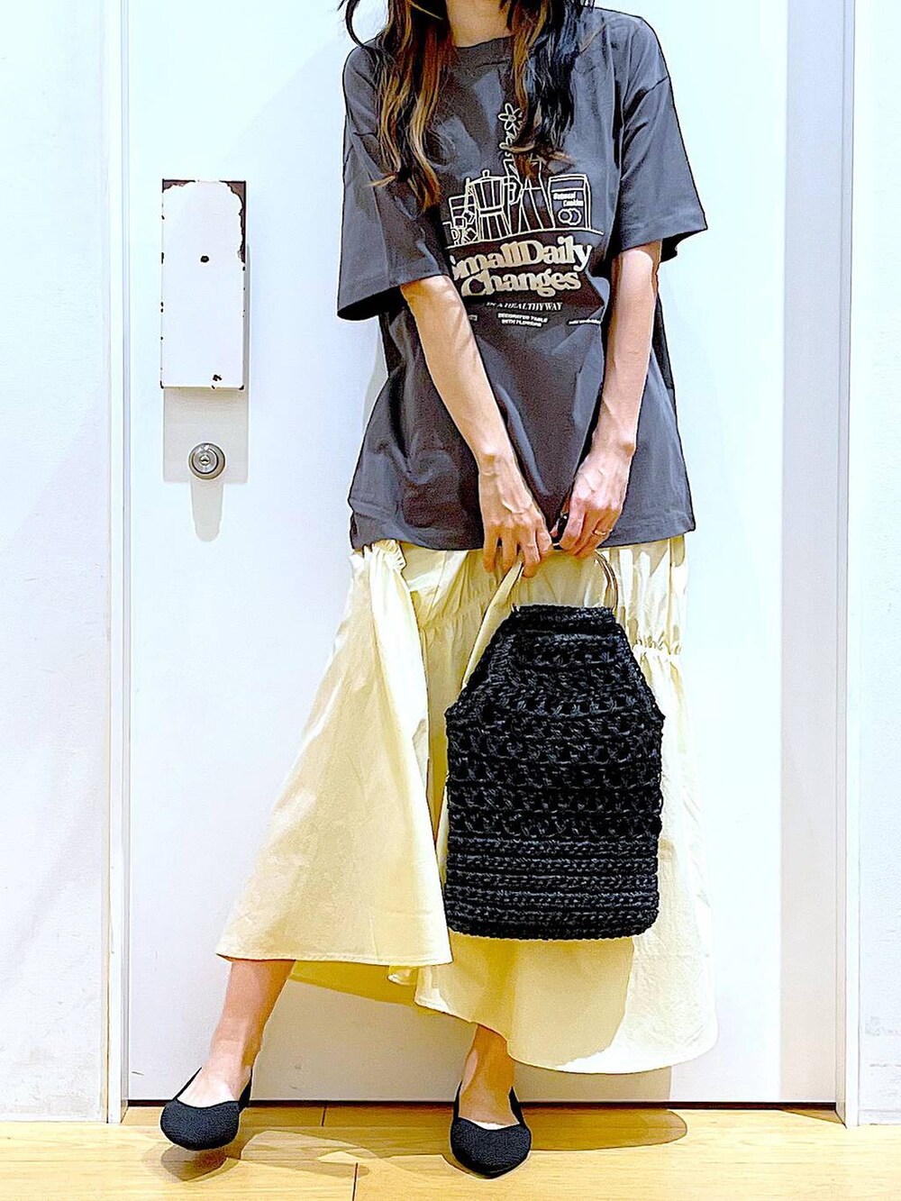 ブラック系のパンプス、グレー系のTシャツ/カットソー、ブラック系のハンドバッグを着用したレディースの春コーディネートの6枚目の写真