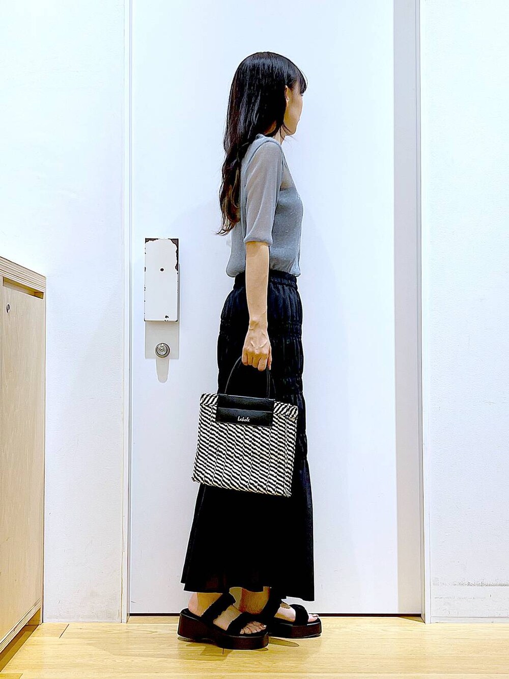 ブラック系のサンダル、ブラック系のショルダーバッグ、ブルー系のTシャツ/カットソーを着用したレディースの夏コーディネートの4枚目の写真