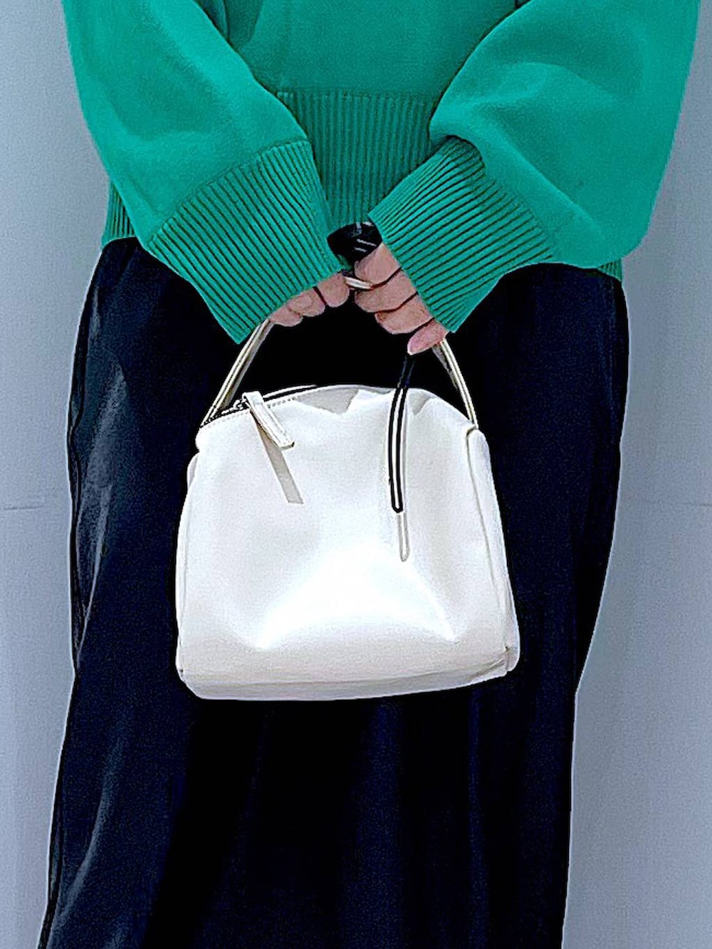 ブラック系のTシャツ/カットソー、ホワイト系のショルダーバッグ、グリーン系のニット/セーターを着用したレディースの春コーディネートの9枚目の写真