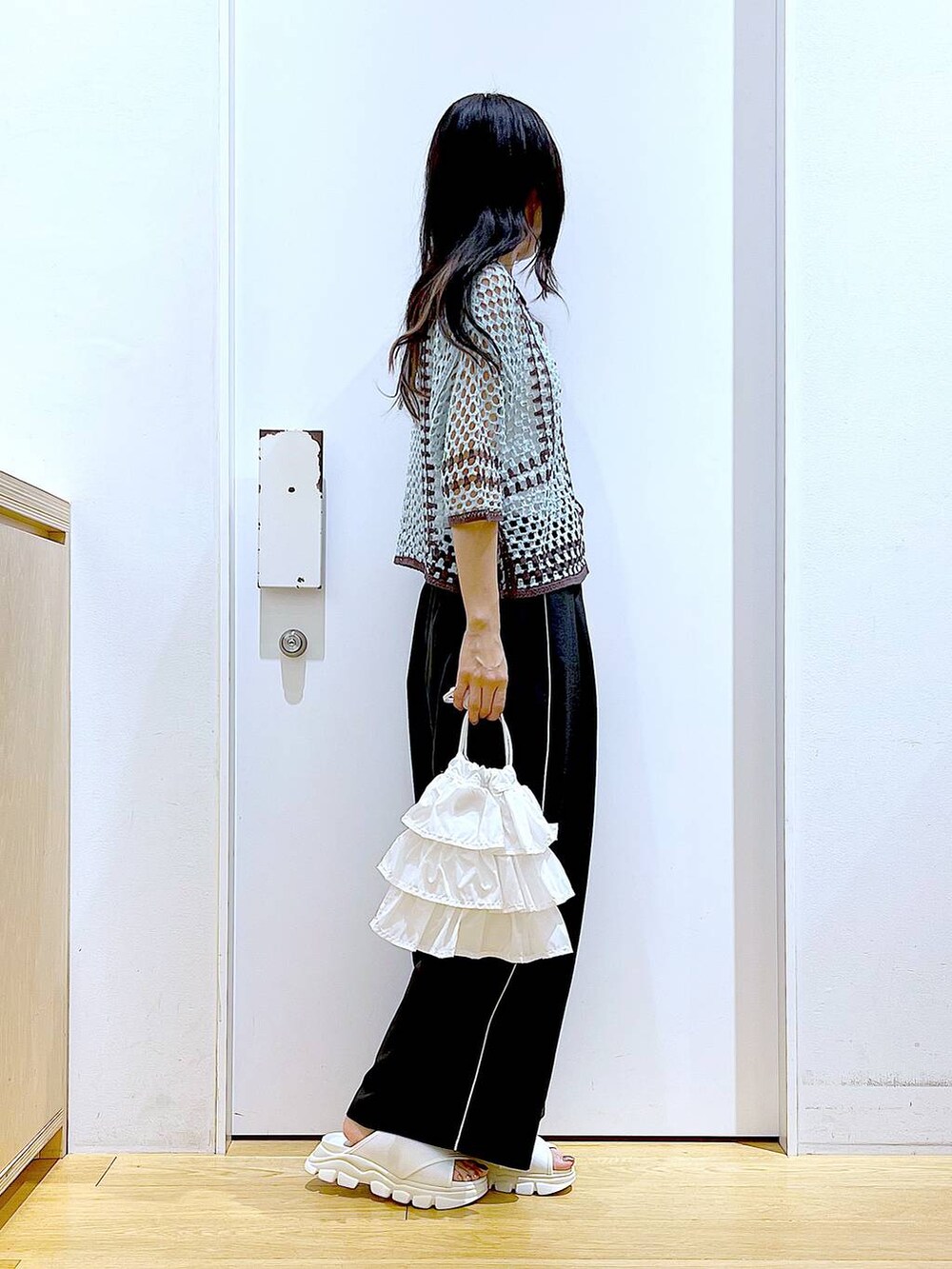 ホワイト系のショルダーバッグ、ホワイト系のサンダル、グリーン系のカーディガン/ボレロを着用したレディースの春コーディネートの4枚目の写真