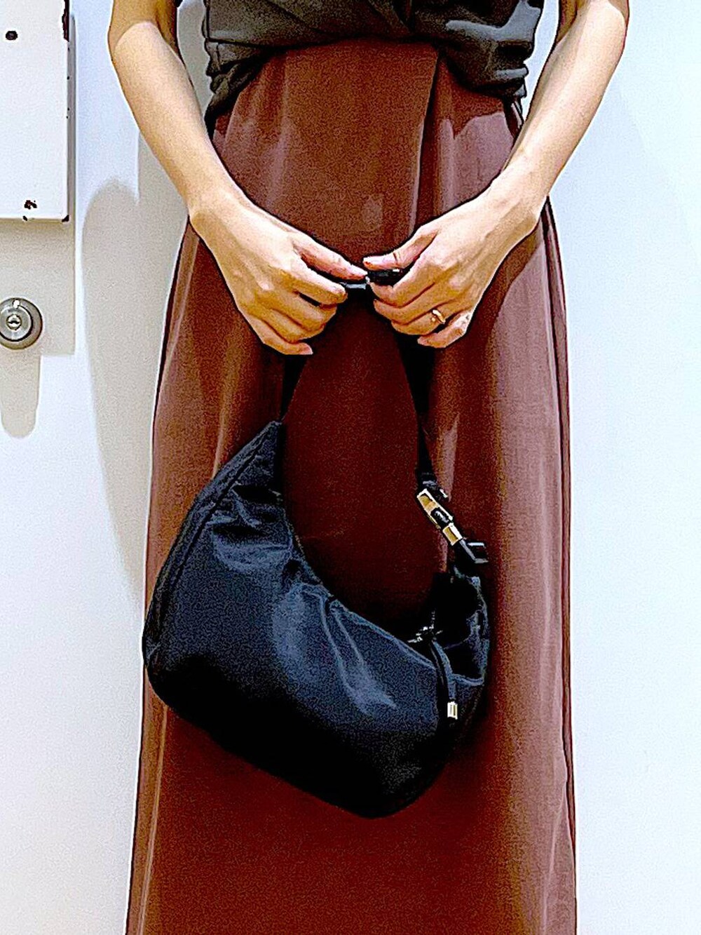 レッド系のワンピース、ブラック系のショルダーバッグ、ホワイト系のパンプスを着用したレディースの春コーディネートの9枚目の写真