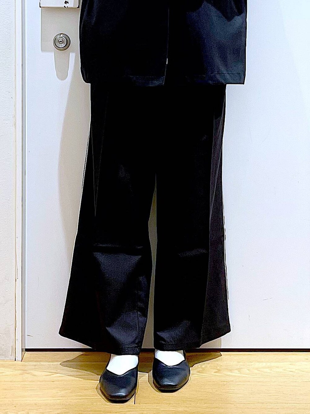 ブラック系のスラックス、ブラック系のパンプス、ホワイト系のスウェットを着用したレディースの春コーディネートの8枚目の写真