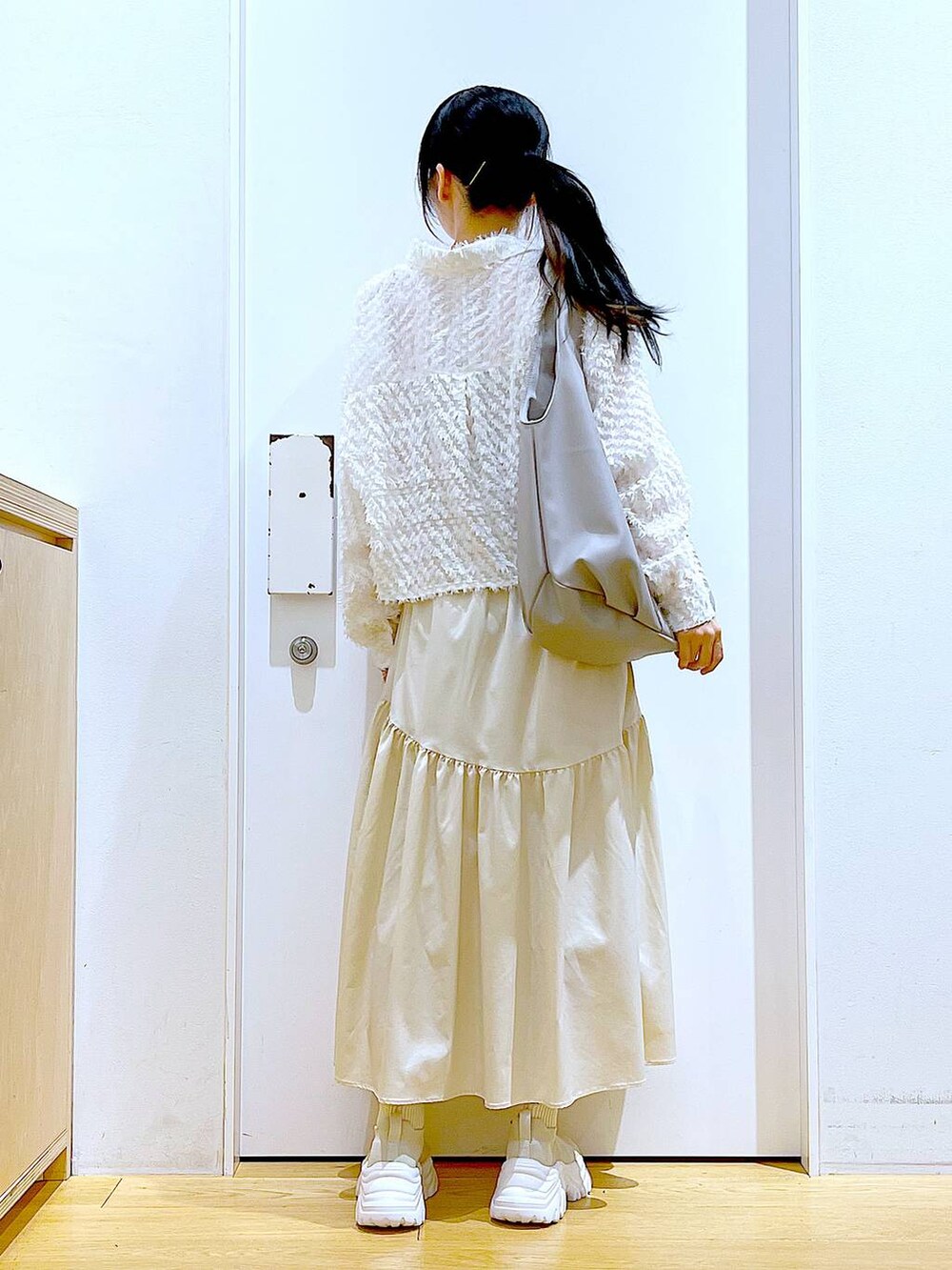 グレー系のトートバッグ、ホワイト系のシャツ/ブラウス、ベージュ系のスニーカーを着用したレディースの春コーディネートの5枚目の写真