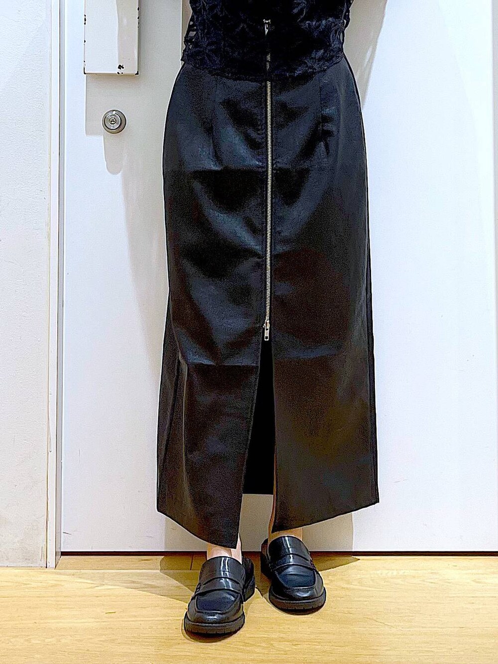 ブラック系のスカート、ブラック系のローファー、ベージュ系のベストを着用したレディースの秋コーディネートの8枚目の写真