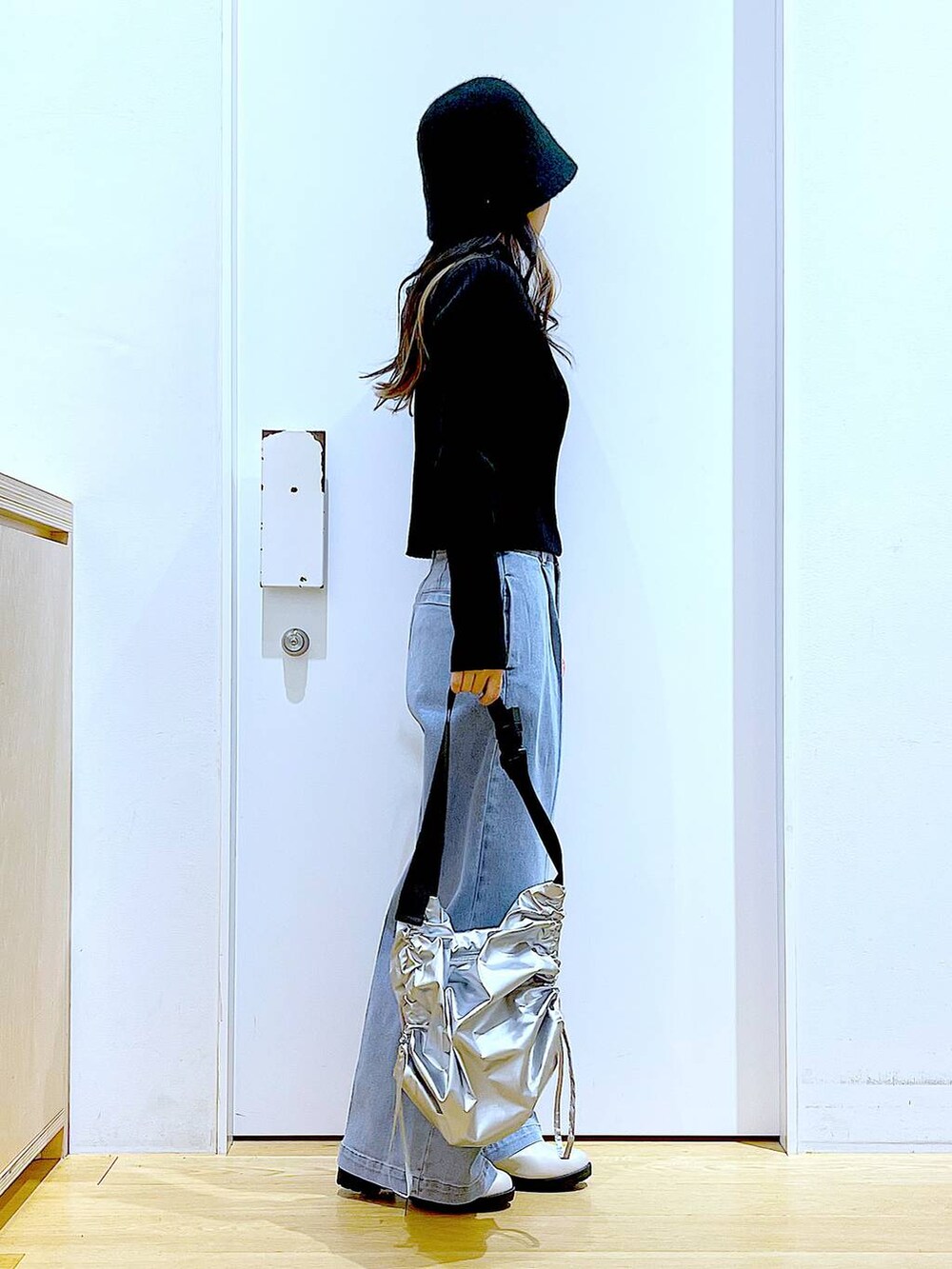 ブルー系のデニムパンツ、ブラック系のカーディガン/ボレロ、ベージュ系のブーツを着用したレディースの冬コーディネートの4枚目の写真