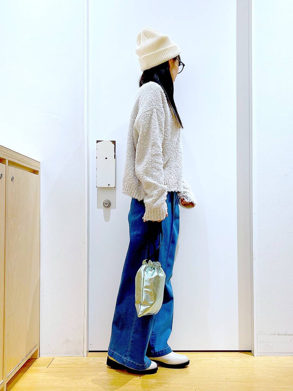 グレー系のニット/セーター、ブルー系のデニムパンツ、ベージュ系のブーツを着用したレディースの冬コーディネートの4枚目の写真