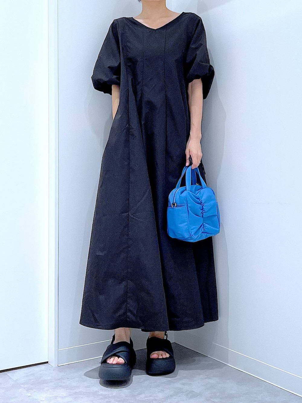 ブラック系のサンダル、ブラック系のワンピースを着用したレディースの夏コーディネートの6枚目の写真