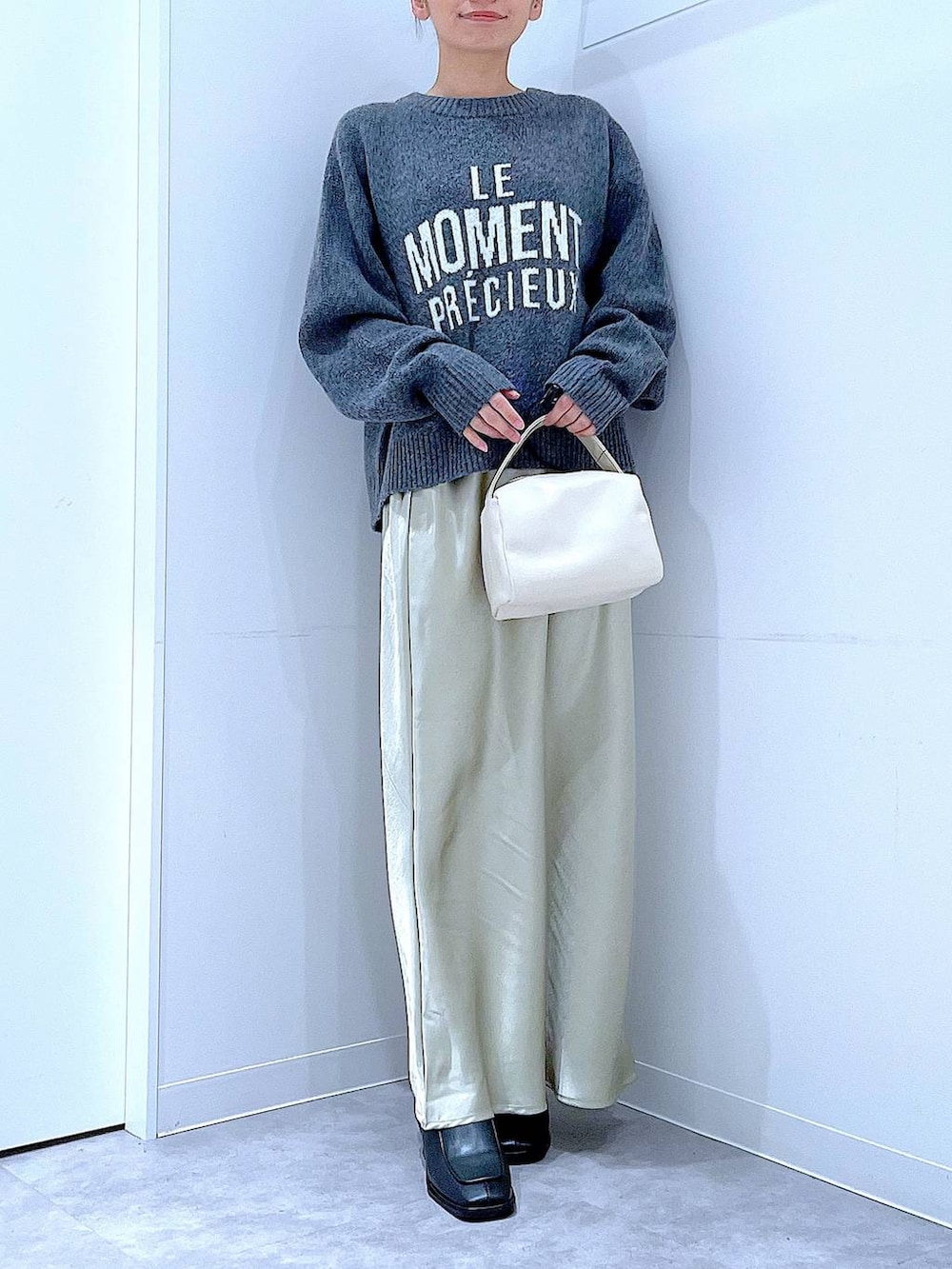 ブラック系のブーツ、グレー系のニット/セーター、ホワイト系のショルダーバッグを着用したレディースの冬コーディネートの6枚目の写真