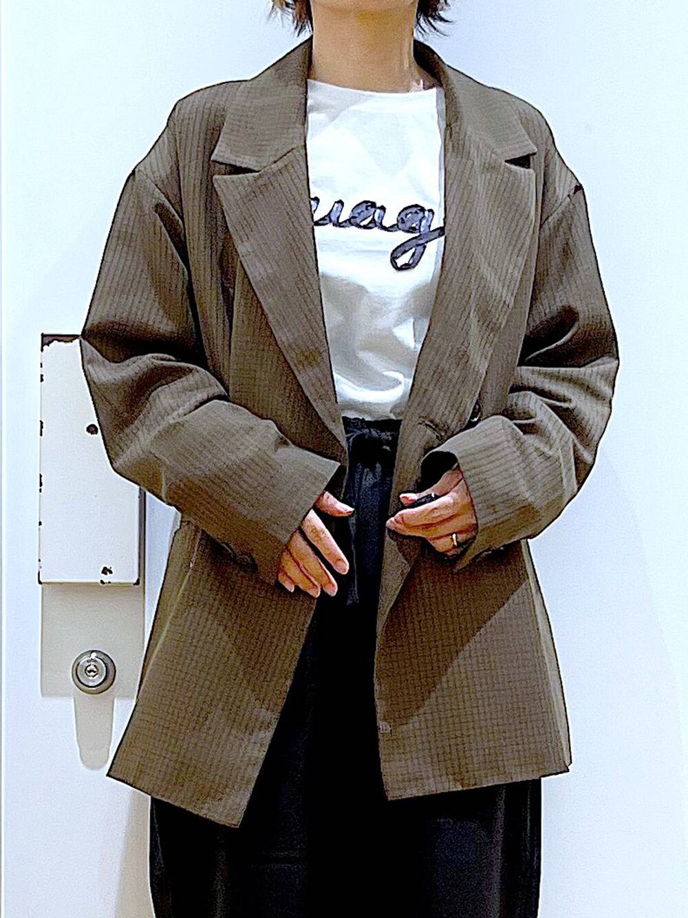 ブラック系のブーツ、ブラック系のショルダーバッグ、ブラウン系のテーラードジャケットを着用したレディースの秋コーディネートの7枚目の写真