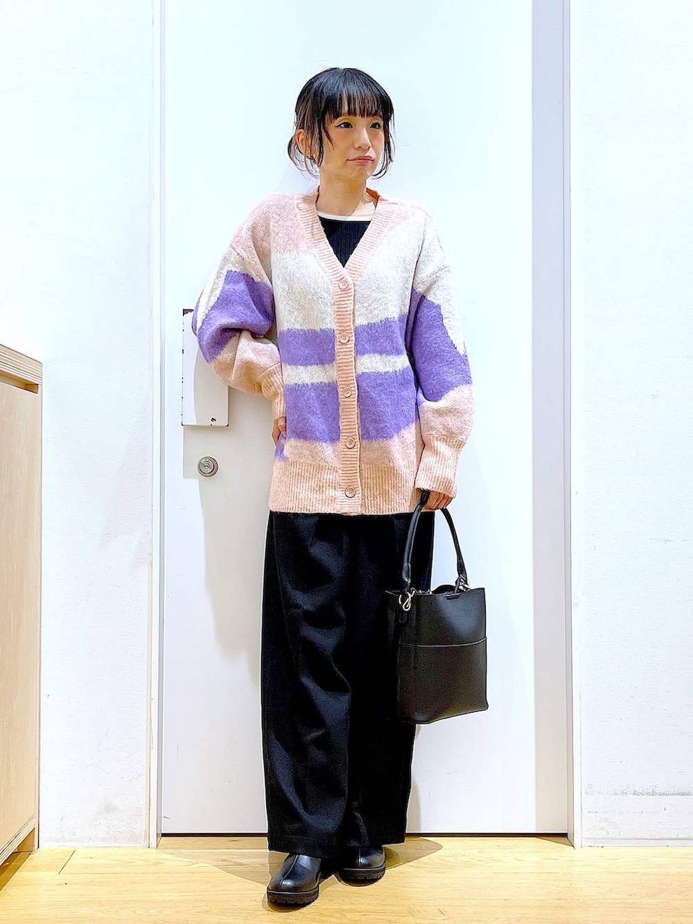 ブラック系のショルダーバッグ、ブラック系のブーツ、ブラック系のニット/セーターを着用したレディースの冬コーディネートの2枚目の写真