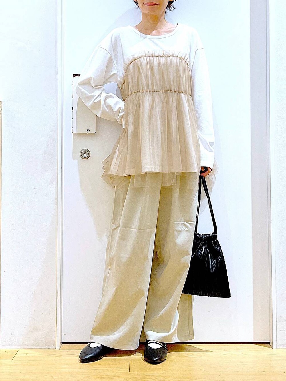 ブラック系のショルダーバッグ、ブラック系のパンプス、ベージュ系のその他パンツを着用したレディースの秋コーディネートの6枚目の写真