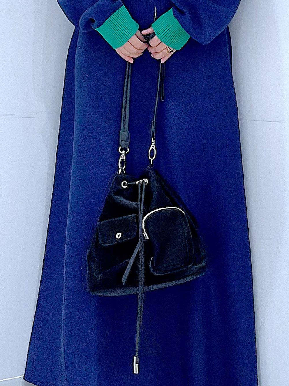 ブラック系のショルダーバッグ、ブラック系のブーツ、ブルー系のスカートを着用したレディースの冬コーディネートの9枚目の写真