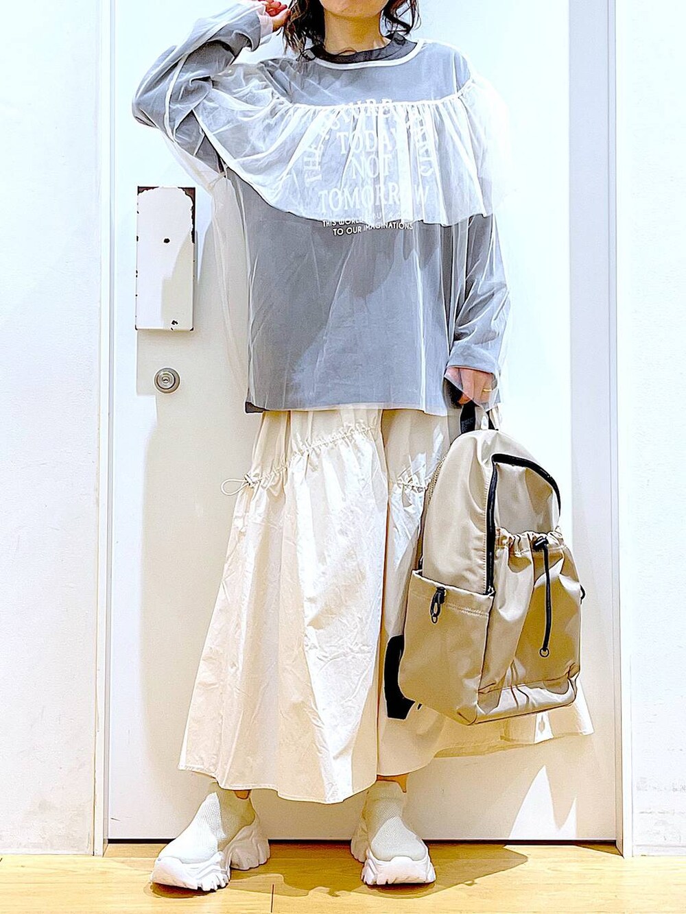 ベージュ系のスニーカー、ホワイト系のその他トップス、ホワイト系のスカートを着用したレディースの春コーディネートの6枚目の写真