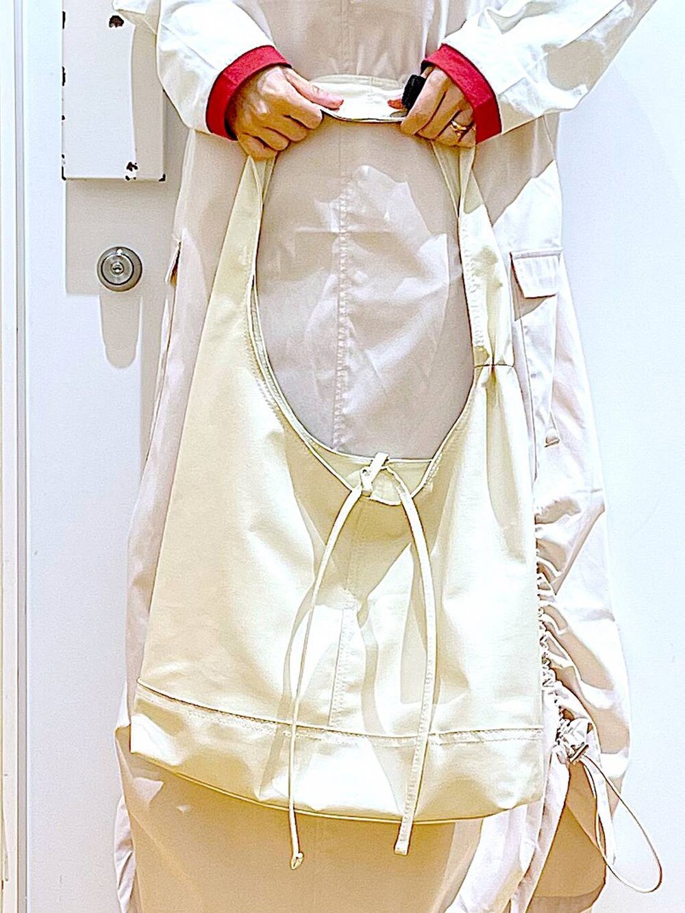 ホワイト系のスニーカー、ベージュ系のジャンパースカート、ベージュ系のTシャツ/カットソーを着用したレディースの春コーディネートの9枚目の写真