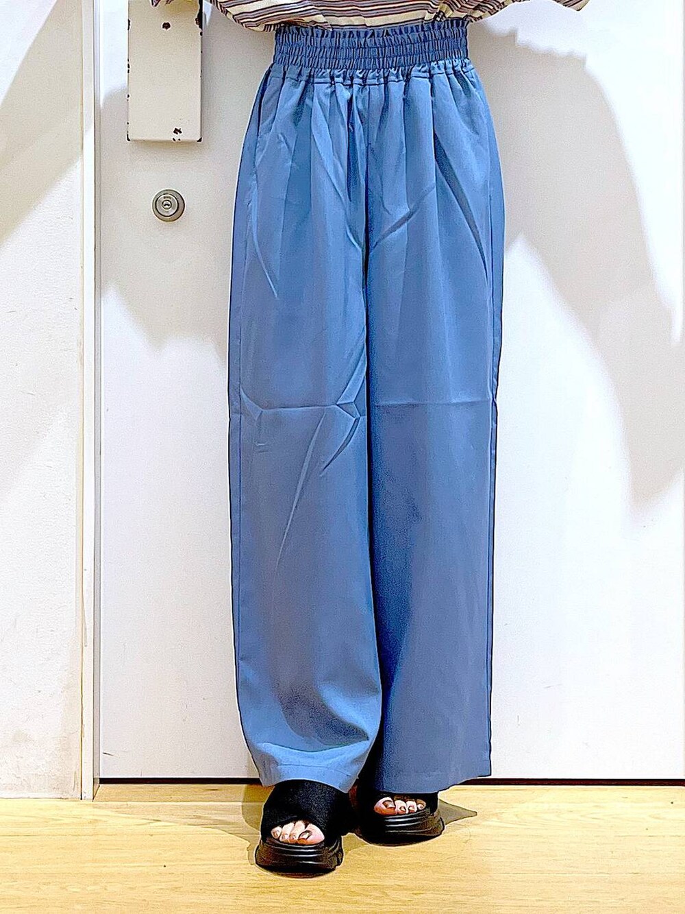 ブラック系のトートバッグ、ブラック系のサンダル、ベージュ系のTシャツ/カットソーを着用したレディースの夏コーディネートの8枚目の写真