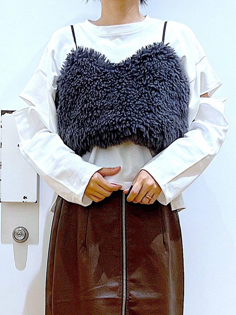 ブラウン系のスカート、グレー系のベスト、ブラック系のローファーを着用したレディースの秋コーディネートの7枚目の写真