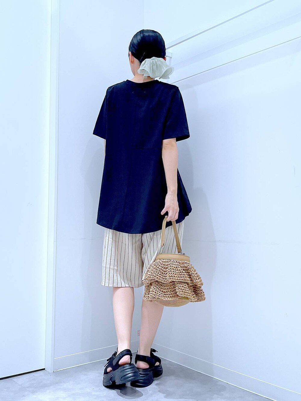 ブラック系のTシャツ/カットソー、ベージュ系のショルダーバッグ、ブラック系のサンダルを着用したレディースの夏コーディネートの5枚目の写真