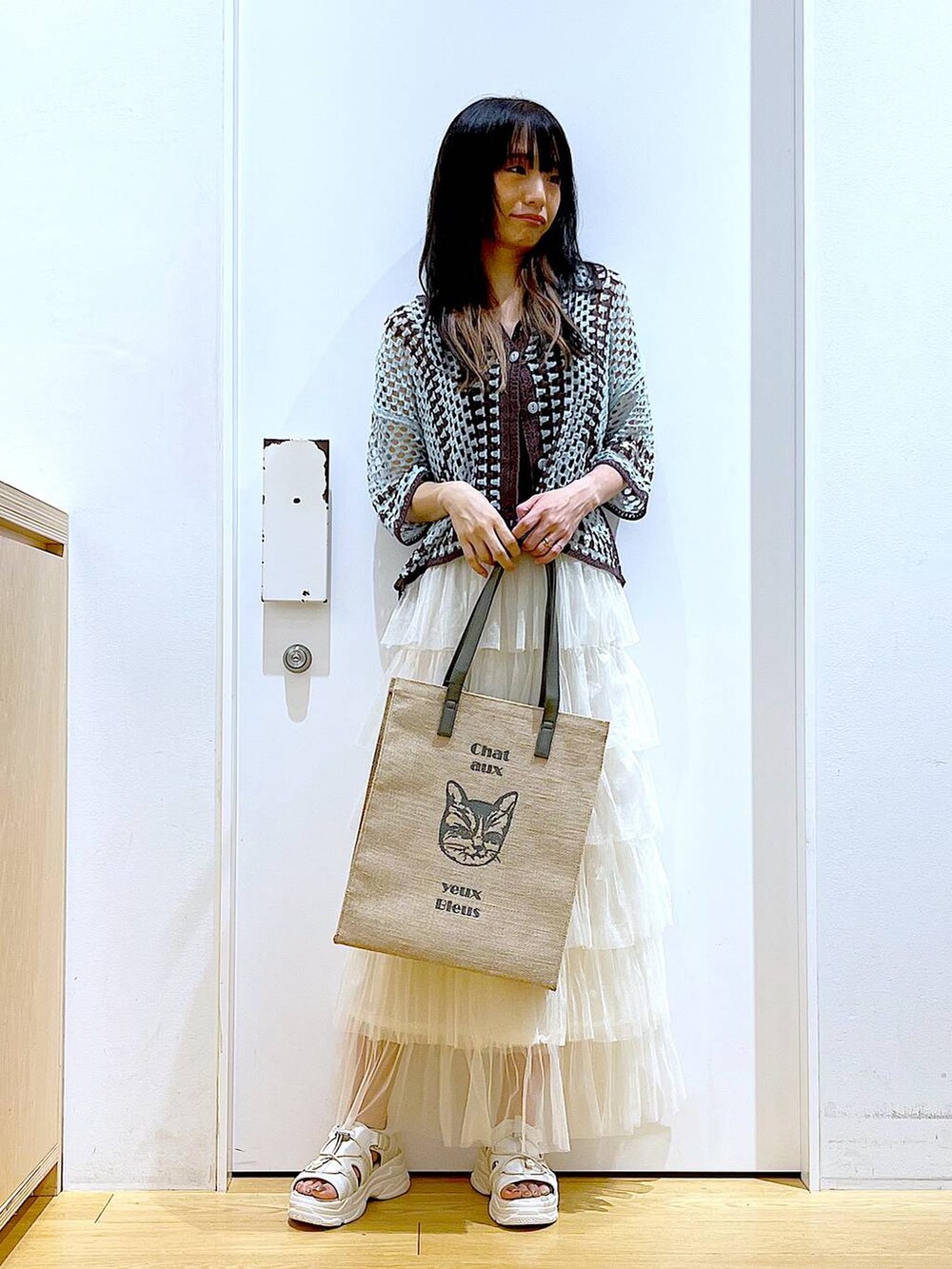 ホワイト系のサンダル、グリーン系のカーディガン/ボレロ、グレー系のトートバッグを着用したレディースの夏コーディネートの2枚目の写真