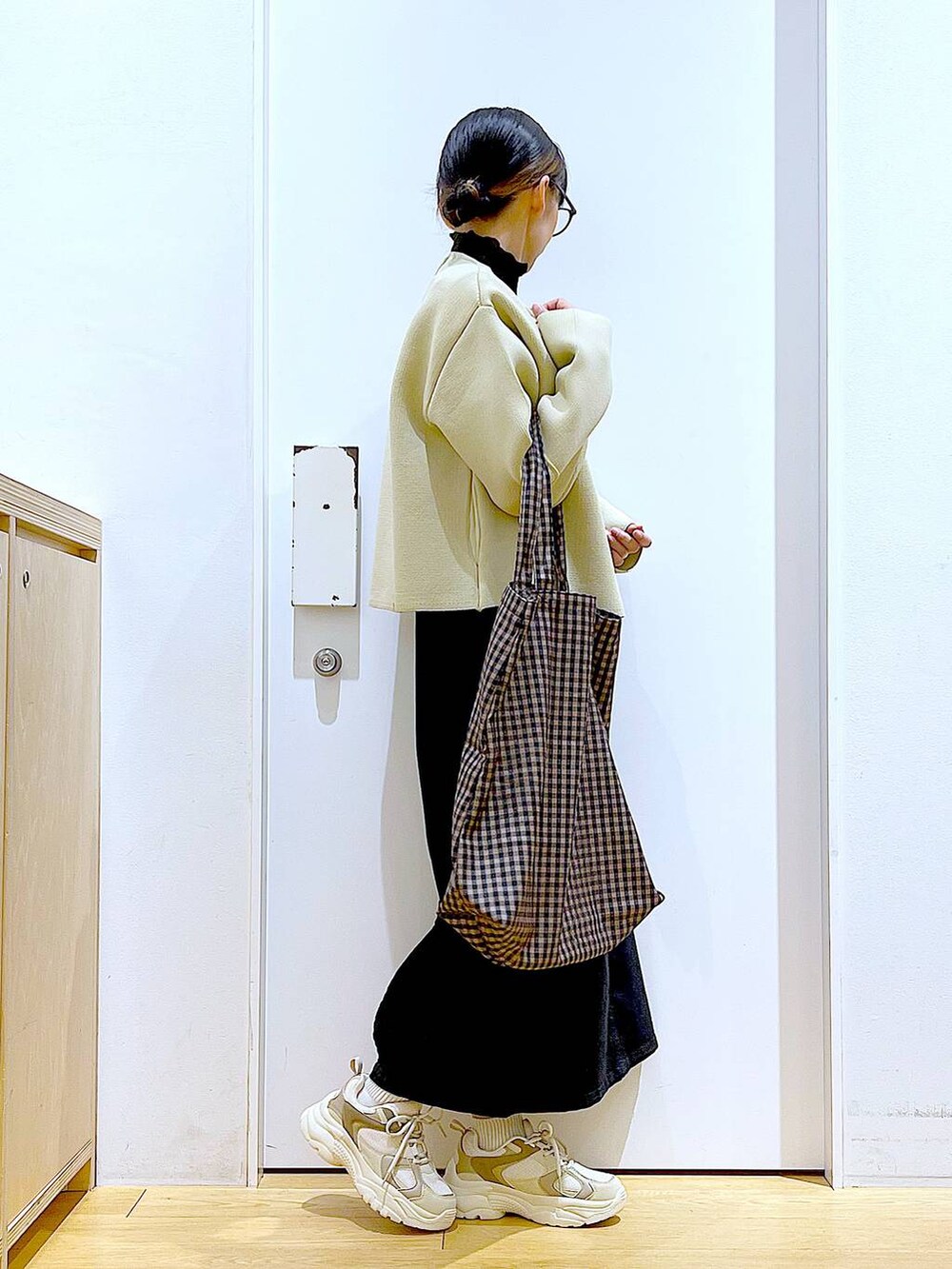 グレー系のジャンパースカート、ブラック系のTシャツ/カットソー、その他のトートバッグを着用したレディースの冬コーディネートの4枚目の写真