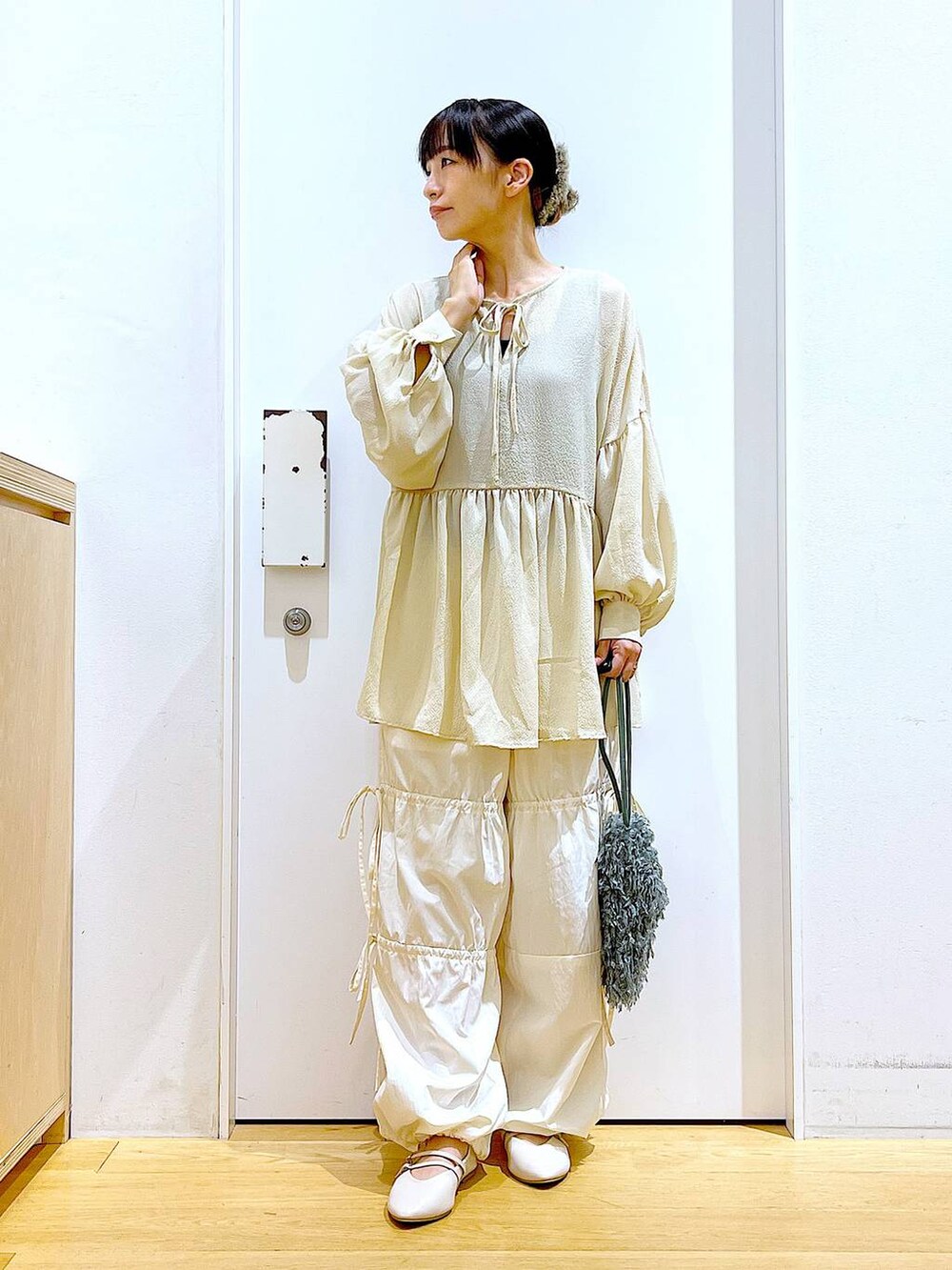 グリーン系のショルダーバッグ、ホワイト系のパンプス、ホワイト系のその他パンツを着用したレディースの秋コーディネートの2枚目の写真