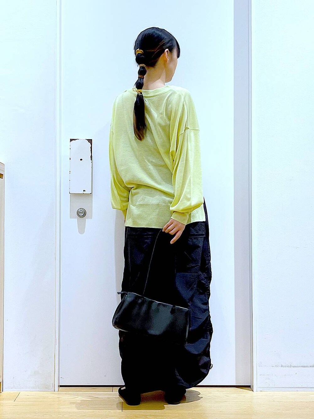 ホワイト系のキャミソール、グリーン系のカーディガン/ボレロ、ブラック系のトートバッグを着用したレディースの春コーディネートの5枚目の写真