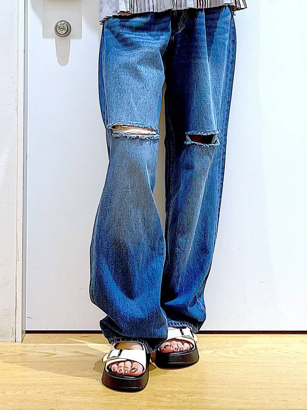 ホワイト系のサンダル、ブラック系のトートバッグ、ブルー系のデニムパンツを着用したレディースの夏コーディネートの8枚目の写真