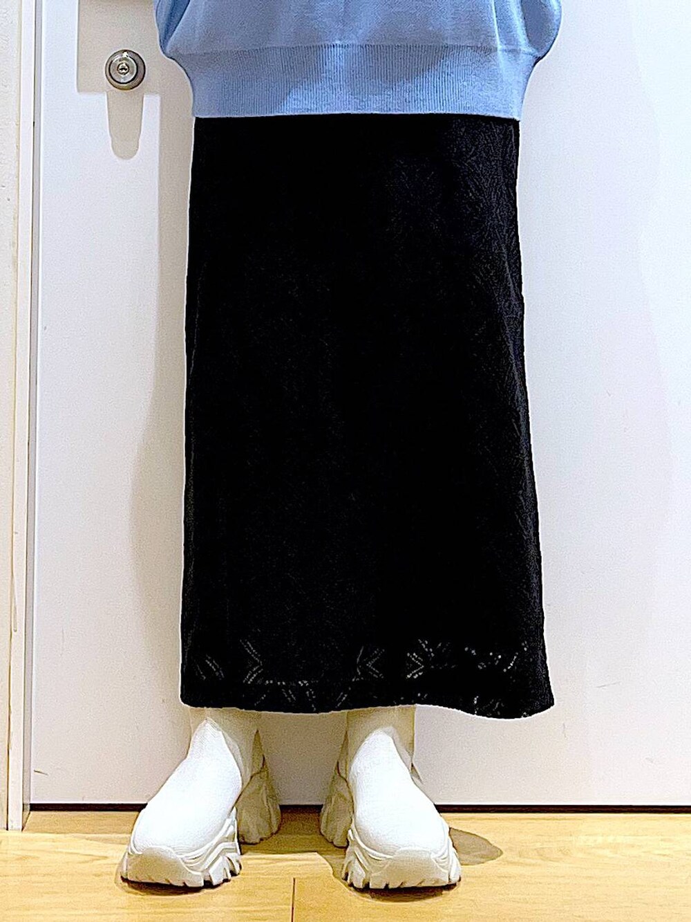 ブルー系のニット/セーター、ホワイト系のショルダーバッグ、ベージュ系のブーツを着用したレディースの冬コーディネートの8枚目の写真