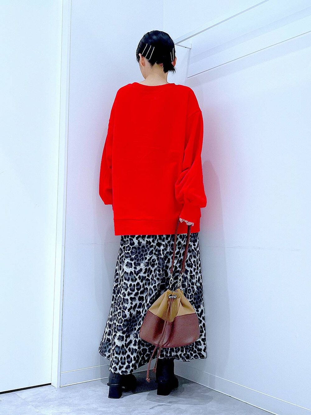 ベージュ系のショルダーバッグ、ブラック系のブーツ、グレー系のスカートを着用したレディースの秋コーディネートの5枚目の写真