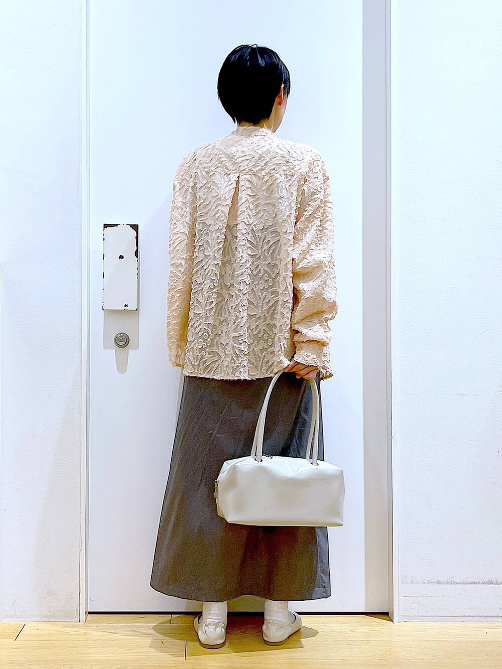 ホワイト系のボストンバッグ、ホワイト系のパンプス、ピンク系のシャツ/ブラウスを着用したレディースの春コーディネートの5枚目の写真
