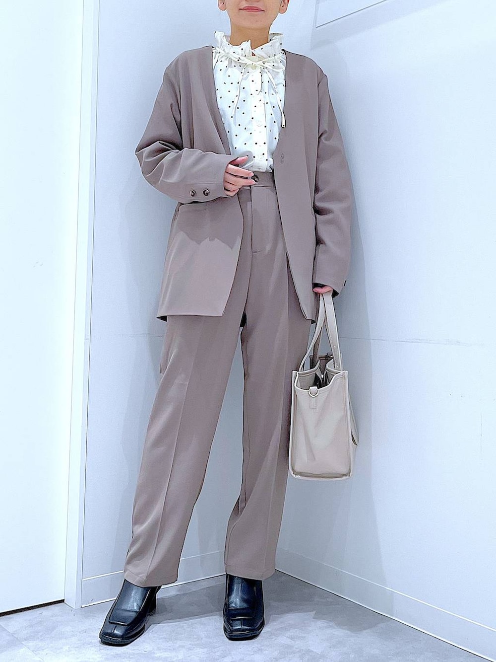 ブラック系のブーツ、グレー系のトートバッグ、ブラウン系のノーカラージャケットを着用したレディースの冬コーディネートの6枚目の写真