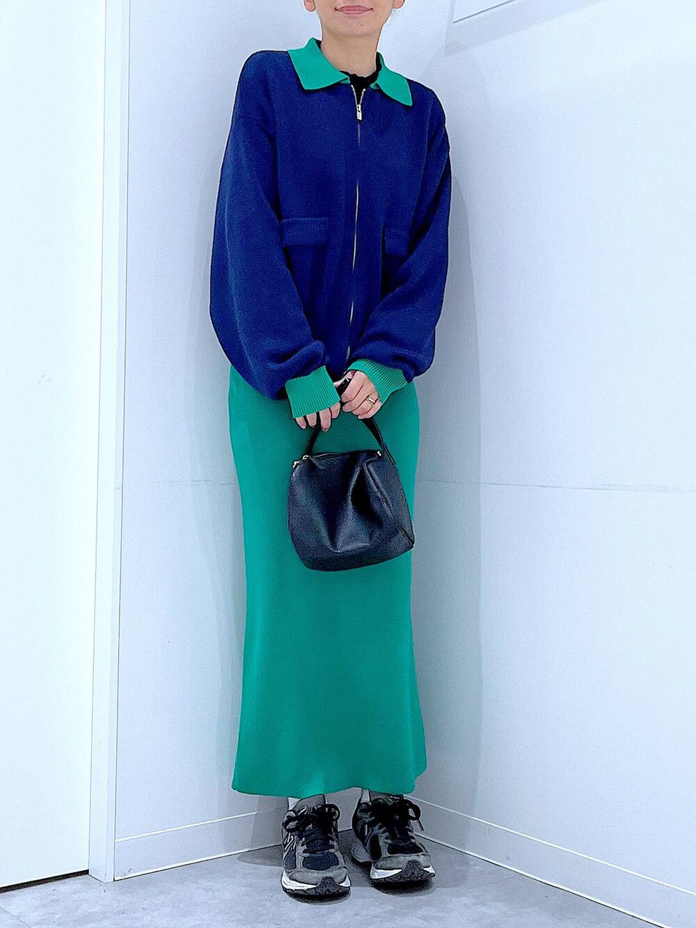 ブラック系のショルダーバッグ、ブルー系のカーディガン/ボレロ、グリーン系のスカートを着用したレディースの春コーディネートの6枚目の写真