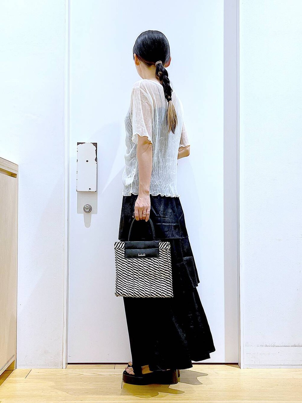 ブラック系のサンダル、ブラック系のショルダーバッグ、ブラック系のスカートを着用したレディースの夏コーディネートの3枚目の写真