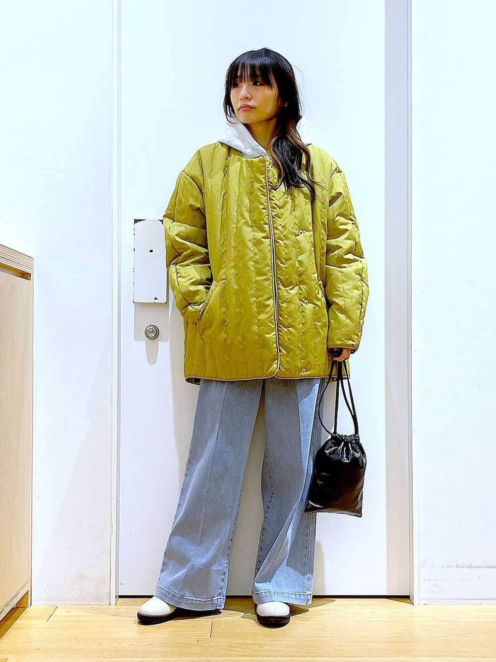 ブルー系のデニムパンツ、ベージュ系のブーツ、ベージュ系のパーカーを着用したレディースの冬コーディネートの2枚目の写真