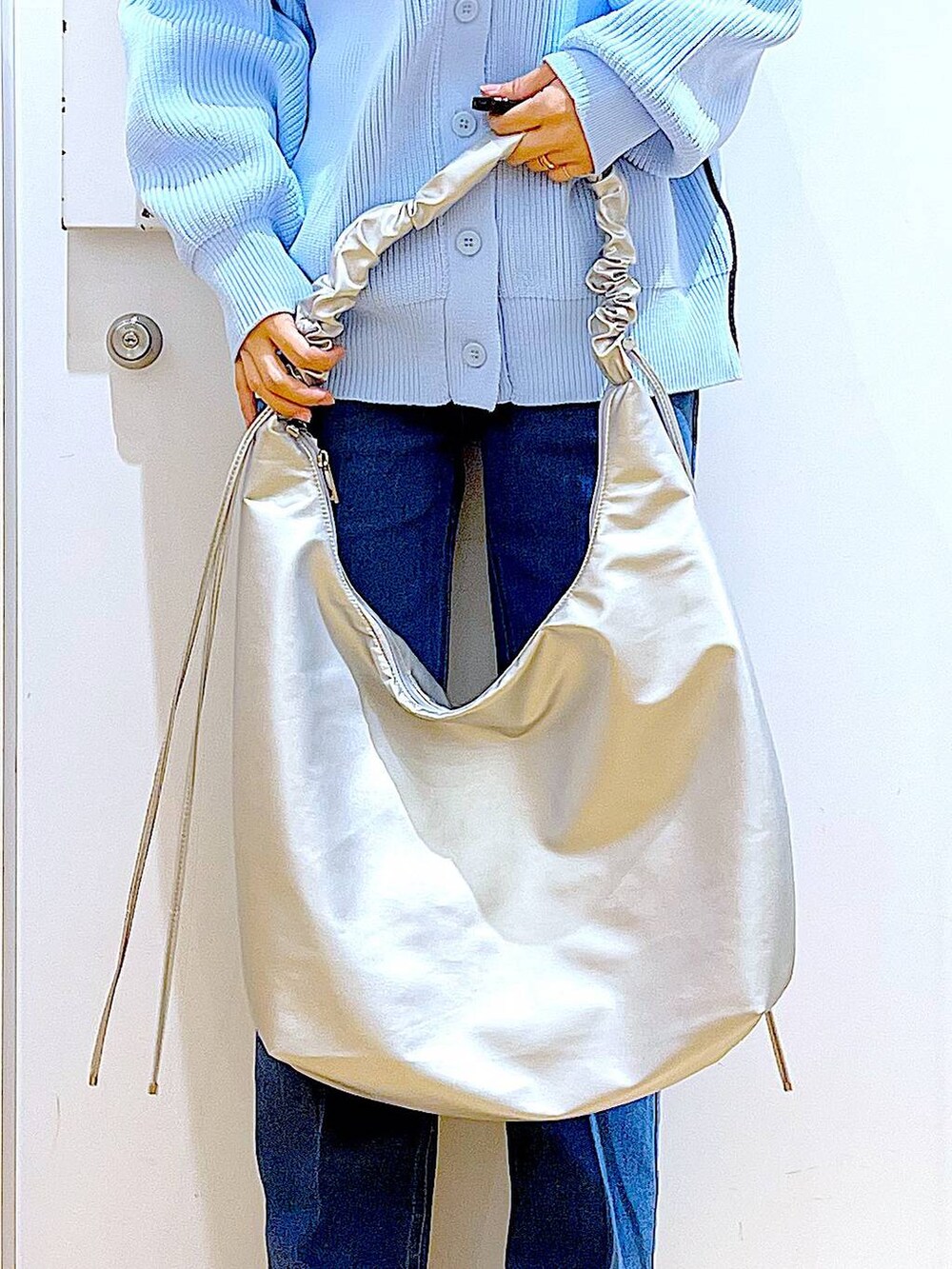 ブルー系のデニムパンツ、ベージュ系のブーツ、ベージュ系のニット/セーターを着用したレディースの冬コーディネートの9枚目の写真