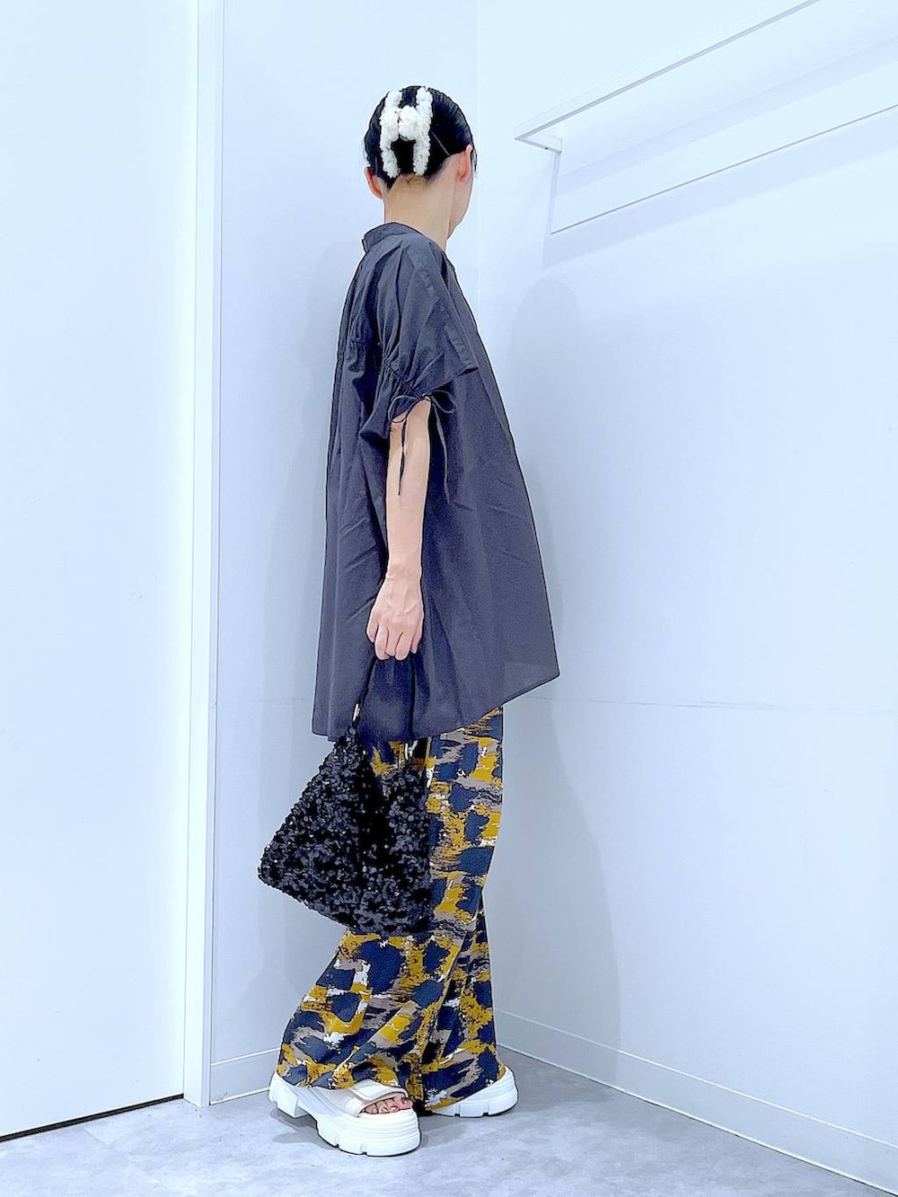 グレー系のその他パンツ、ブラック系のショルダーバッグ、ホワイト系のサンダルを着用したレディースの夏コーディネートの4枚目の写真