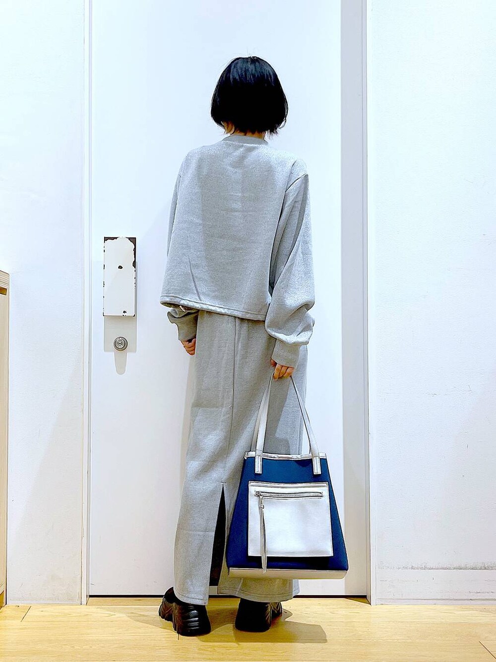 ブラック系のブーツ、ブルー系のトートバッグ、グレー系のスウェットを着用したレディースの冬コーディネートの5枚目の写真