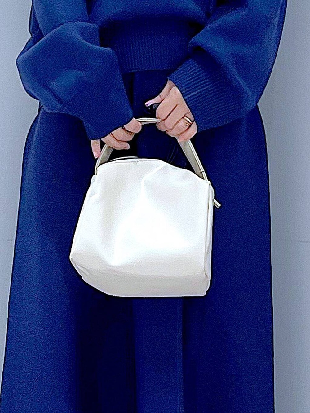 ブラック系のブーツ、ホワイト系のショルダーバッグ、ブルー系のスカートを着用したレディースの冬コーディネートの9枚目の写真