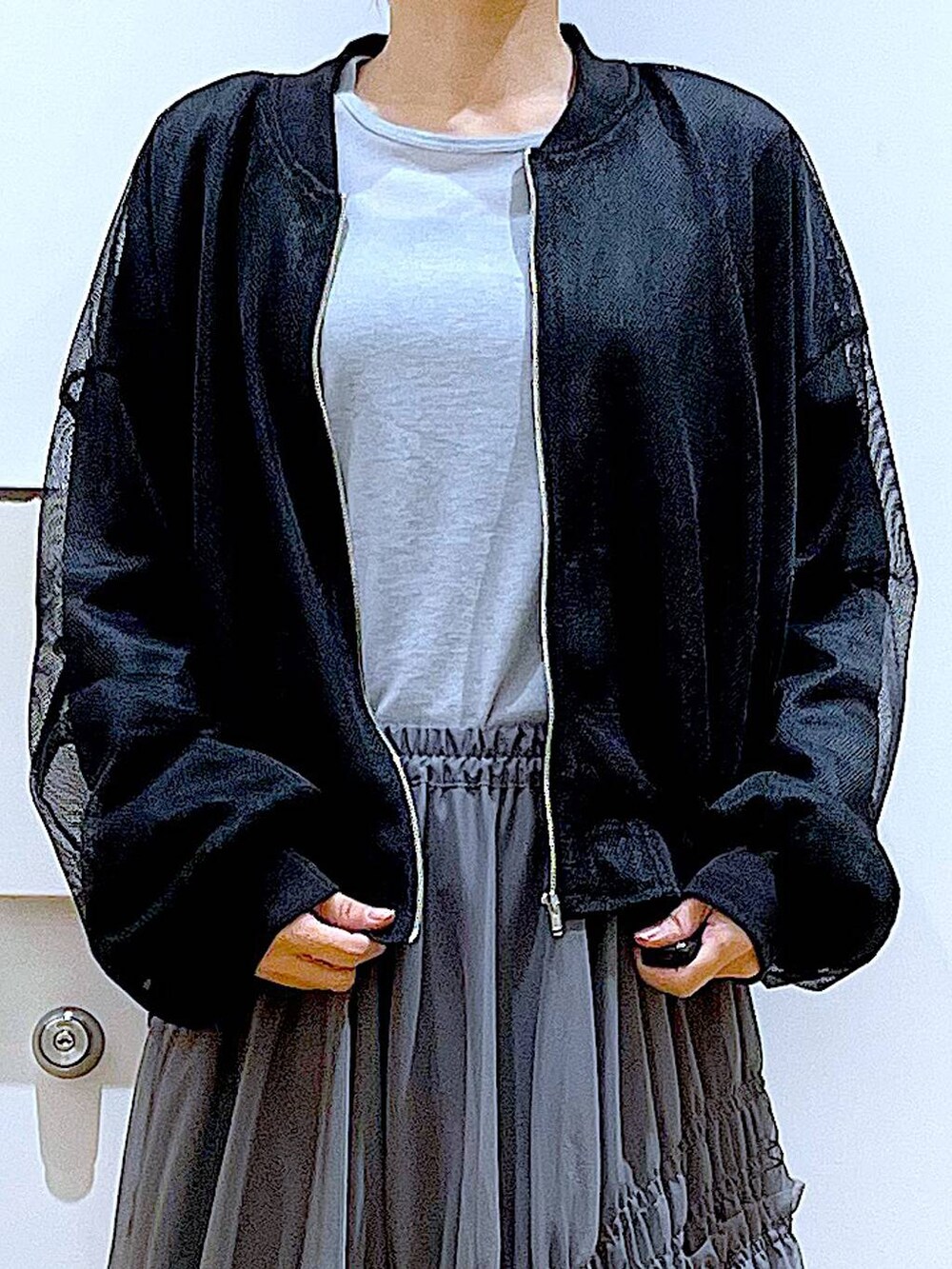 ブラック系のショルダーバッグ、ブラック系のブルゾン、ブルー系のTシャツ/カットソーを着用したレディースの春コーディネートの7枚目の写真